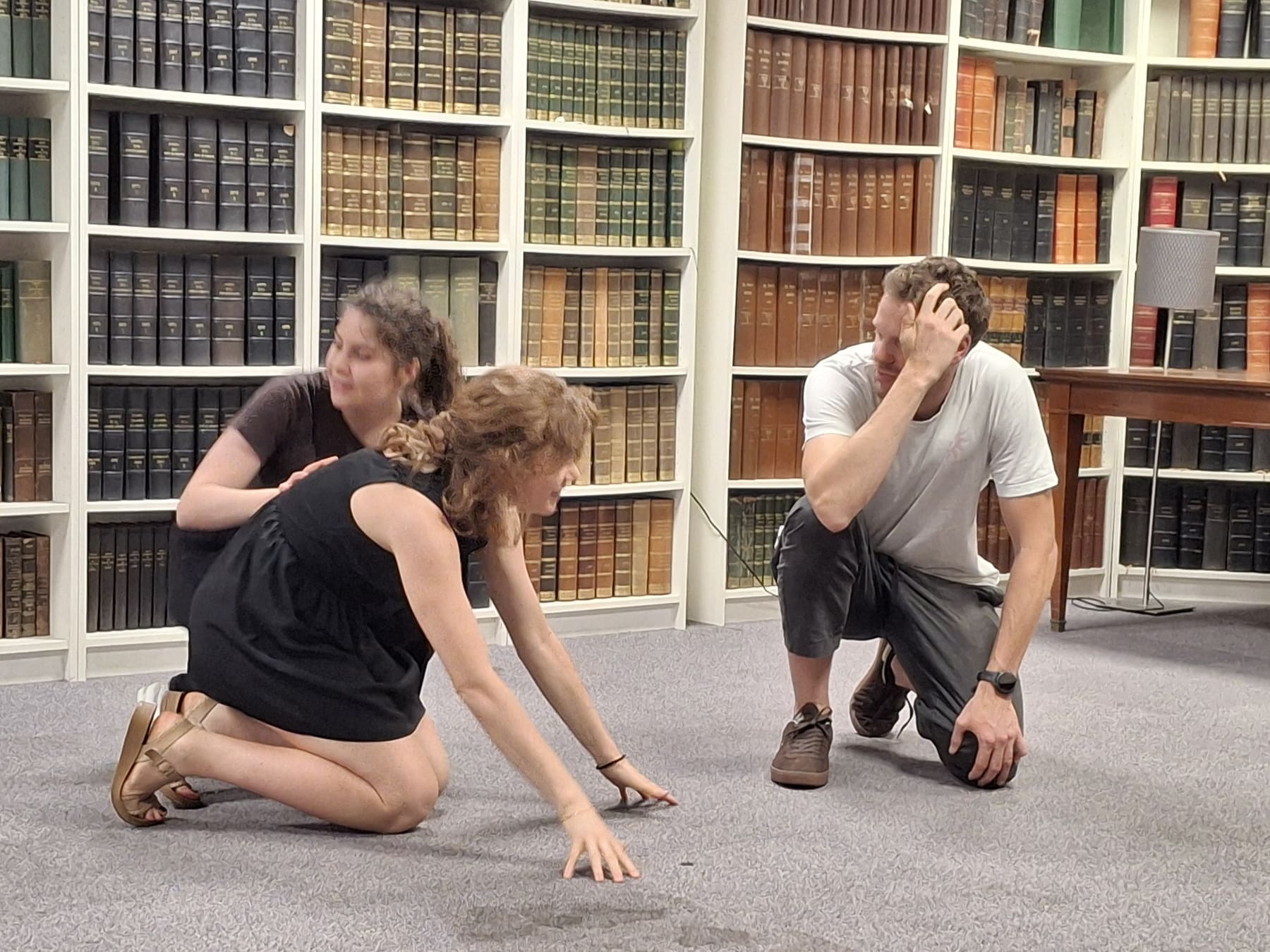 Trois improvisateurs jouent une scène au sol pendant un atelier